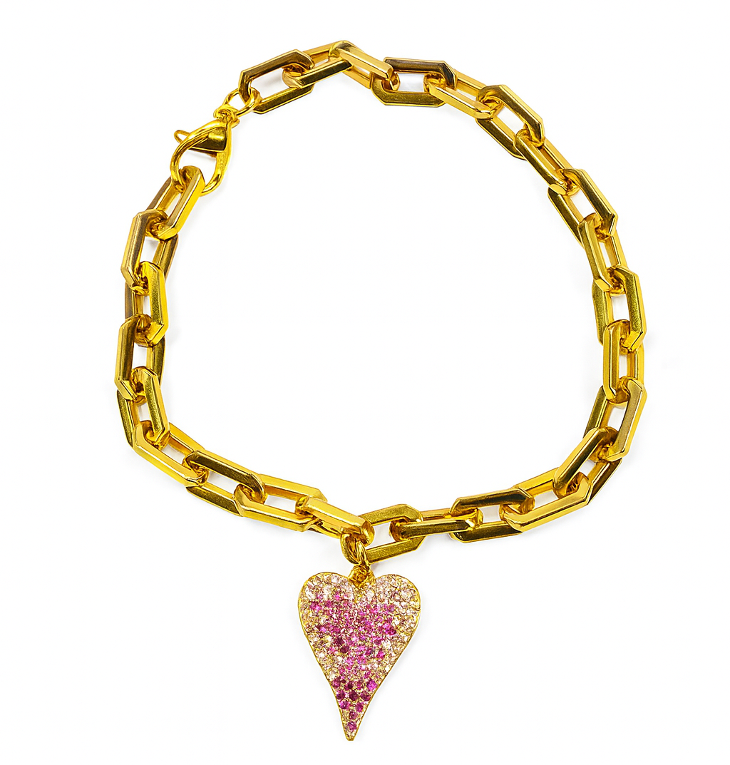 Gold chain bracelet with a pink heart-shaped charm on a white background
