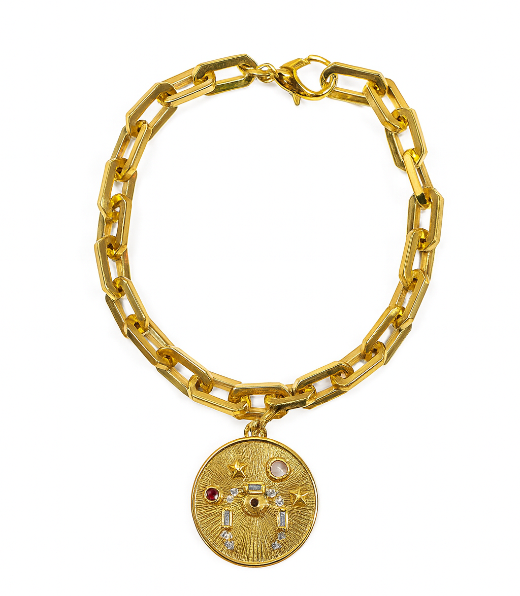 Gold chain bracelet with a decorative round charm on a white background