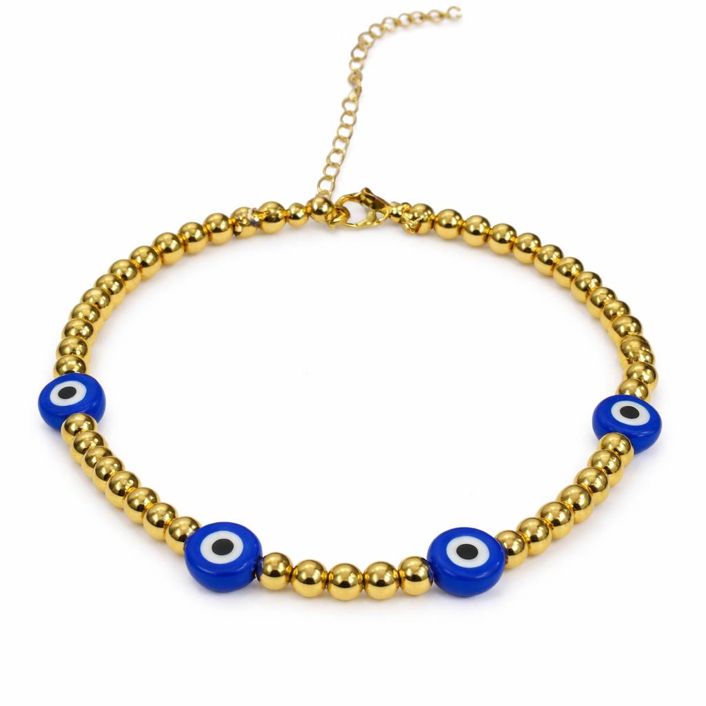 Gold beaded bracelet featuring blue evil eye beads by The Skylar Project on a white background.