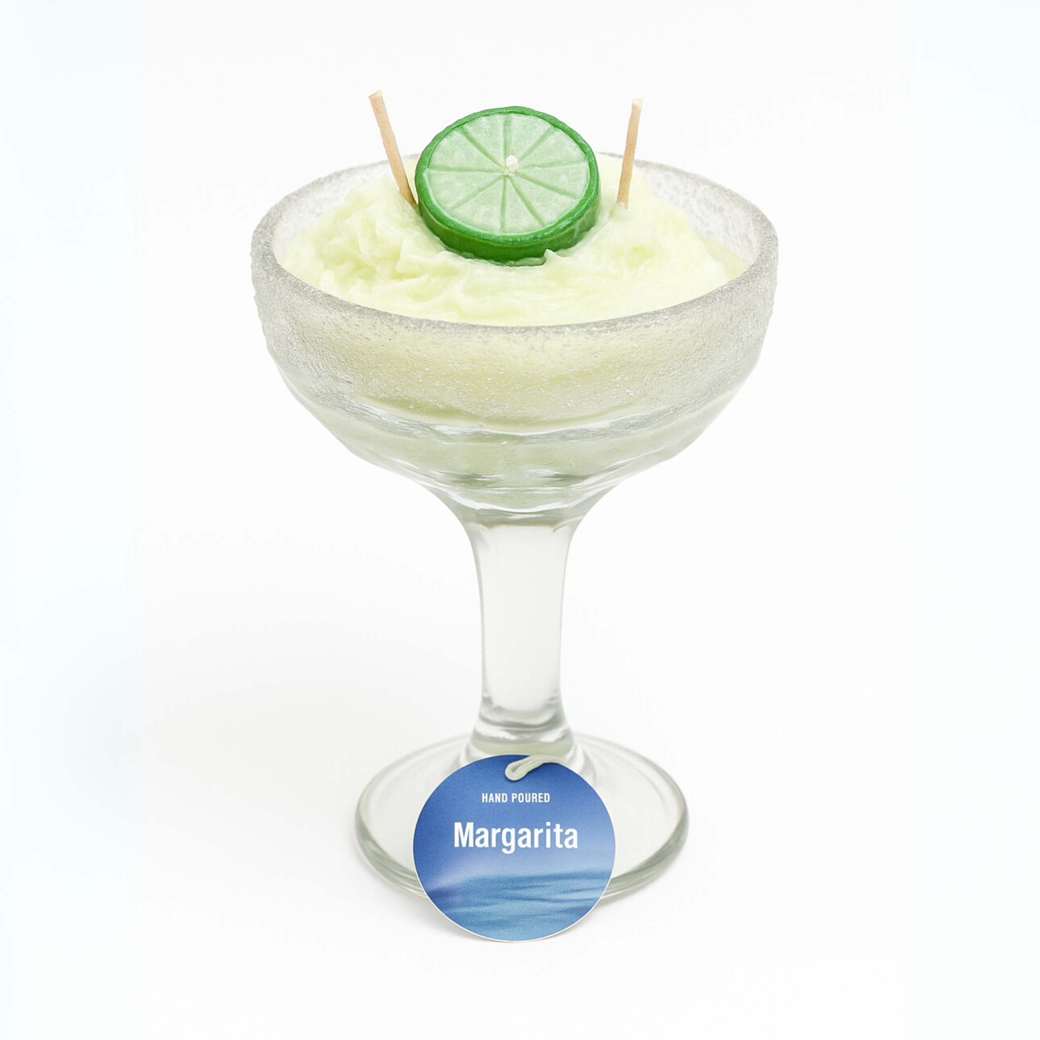 Margarita cocktail candle with lime wedge and toothpicks on a white background