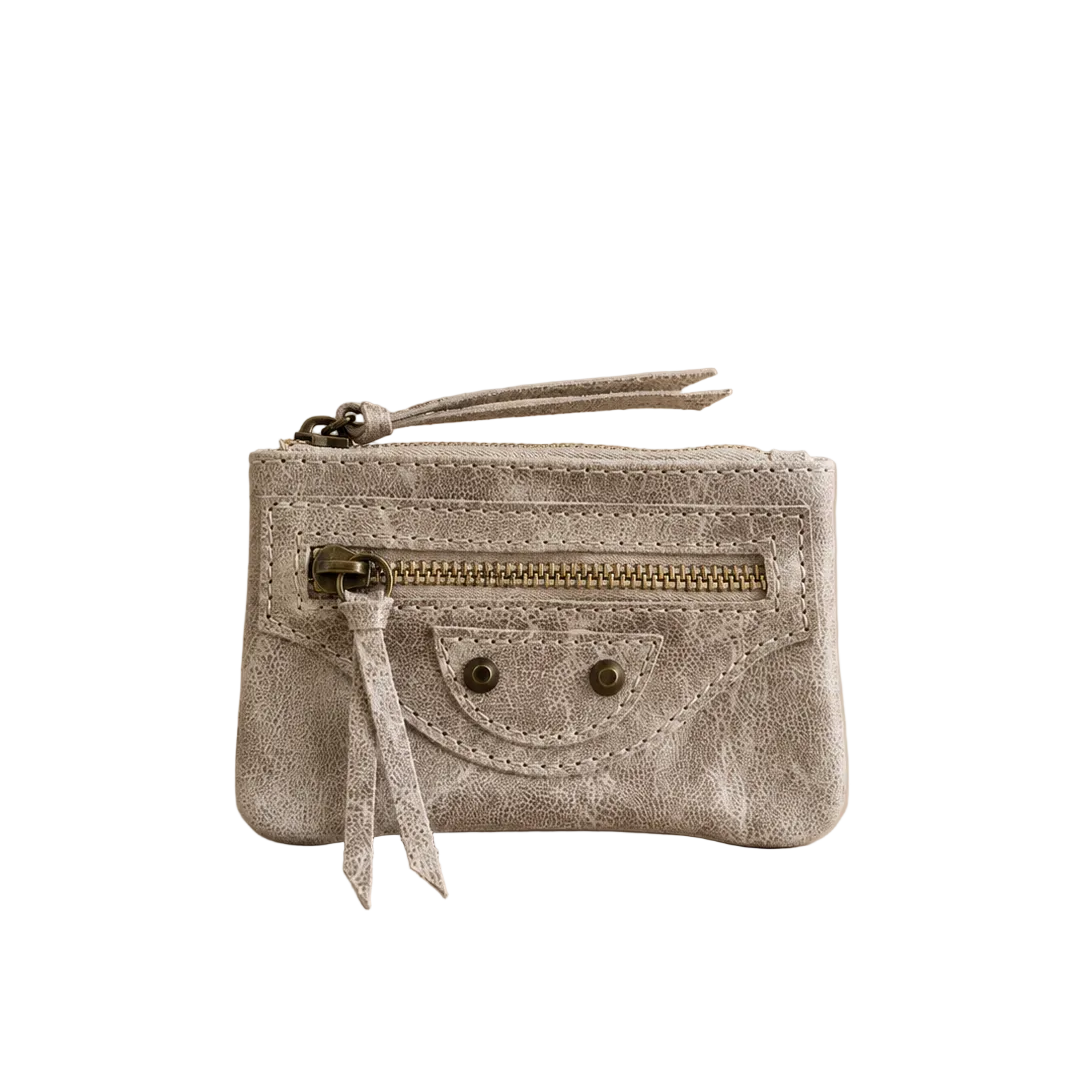Small gray velvet pouch with gold zipper on a beige background