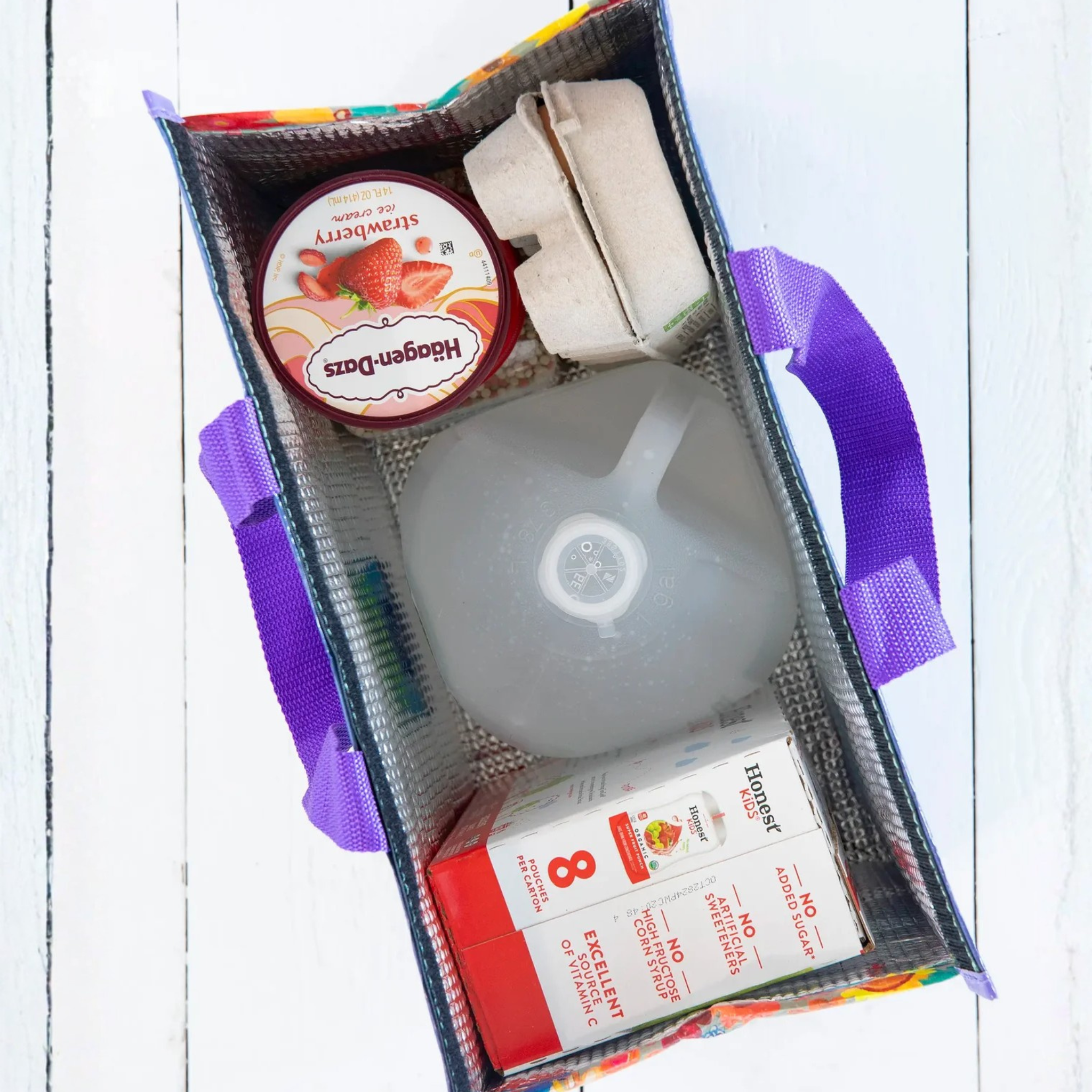 Dusty blue insulated cooler tote with folk flower design by Natural Life, showcasing its spacious interior and sturdy handles.