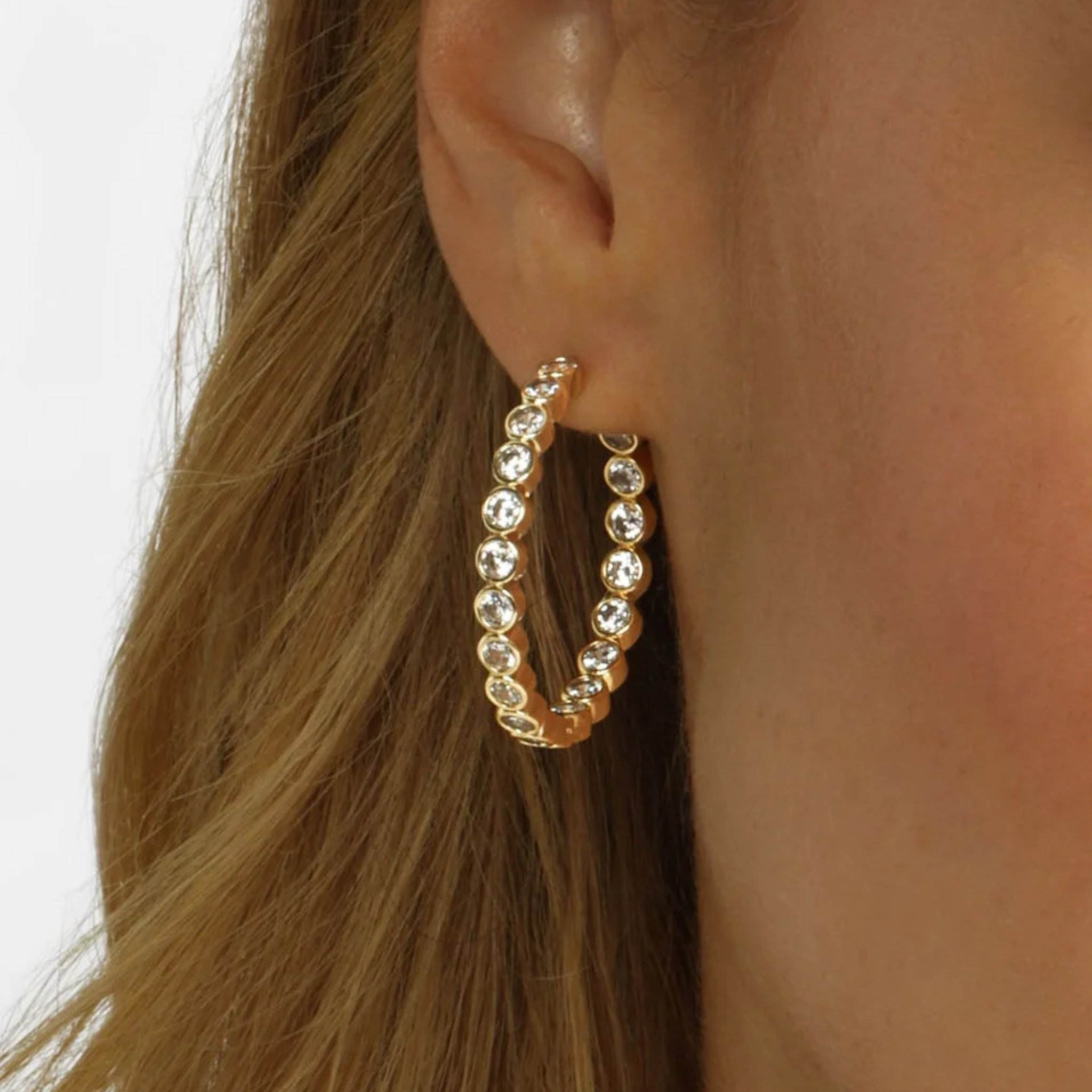 Gold Baroness Hoops earrings by Melinda Maria with white diamondette accents, 1.25-inch size, and a sleek hoop design.