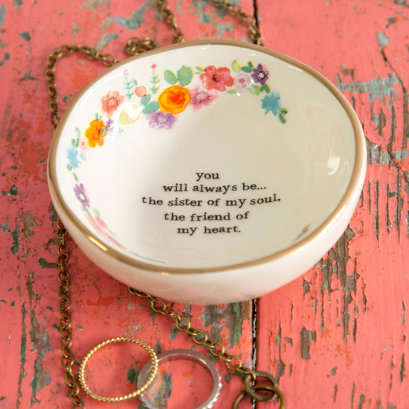 Necklace with a decorative pendant on a textured pink surface