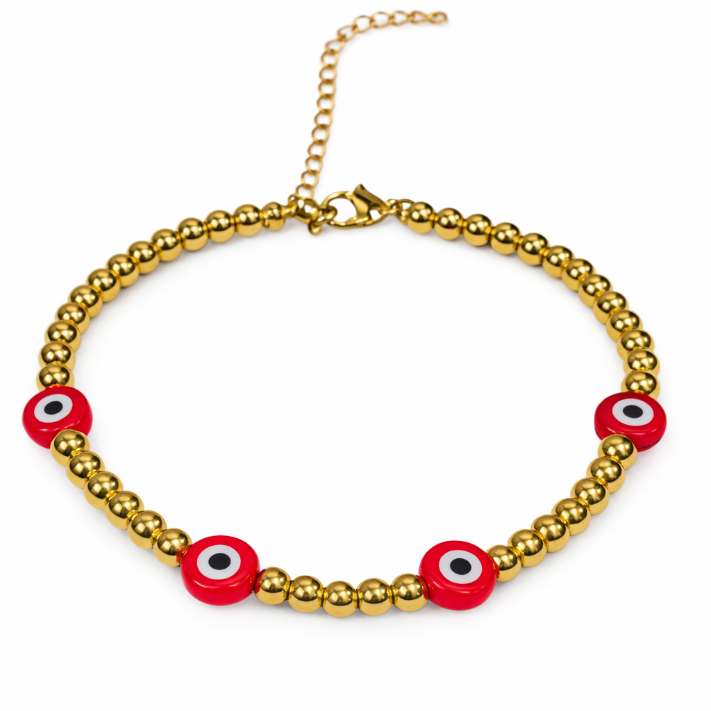 Gold beaded bracelet featuring red evil eye beads, designed by The Skylar Project on a white background.