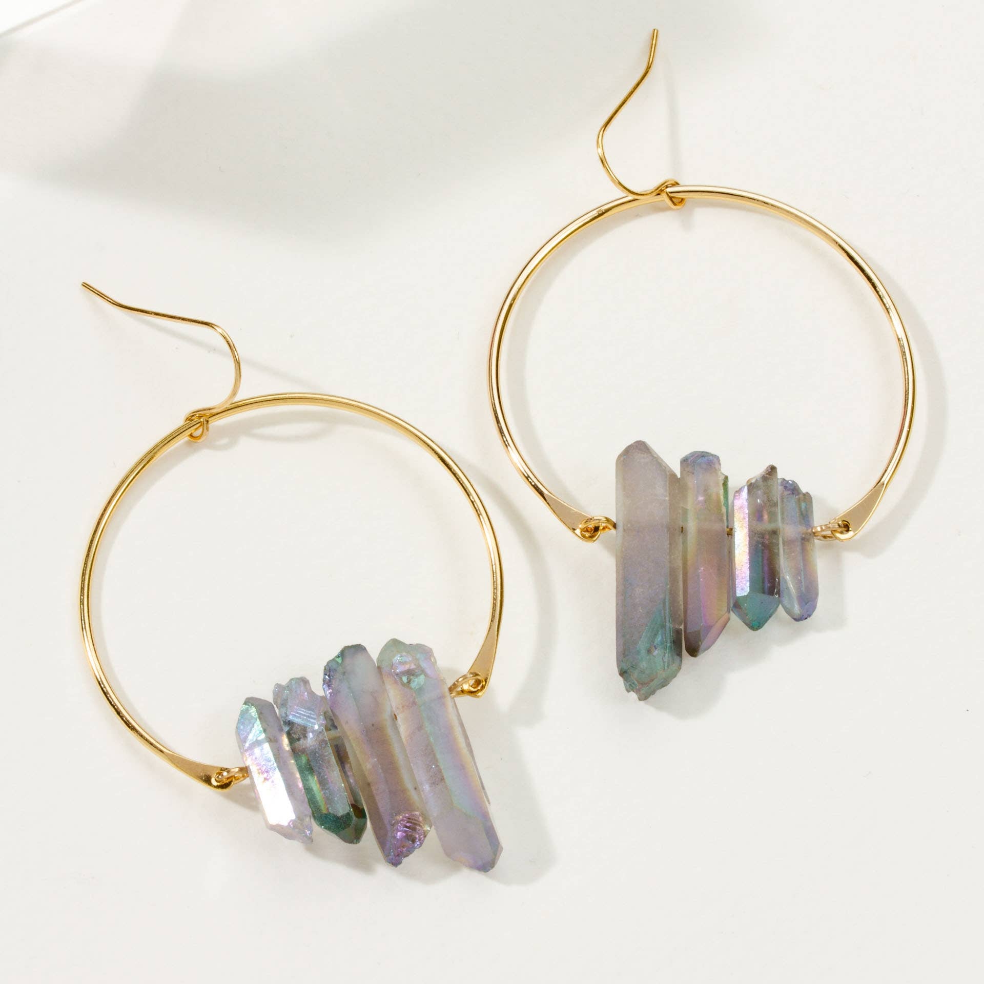 Gold hoop earrings with multicolored stone accents on a white background