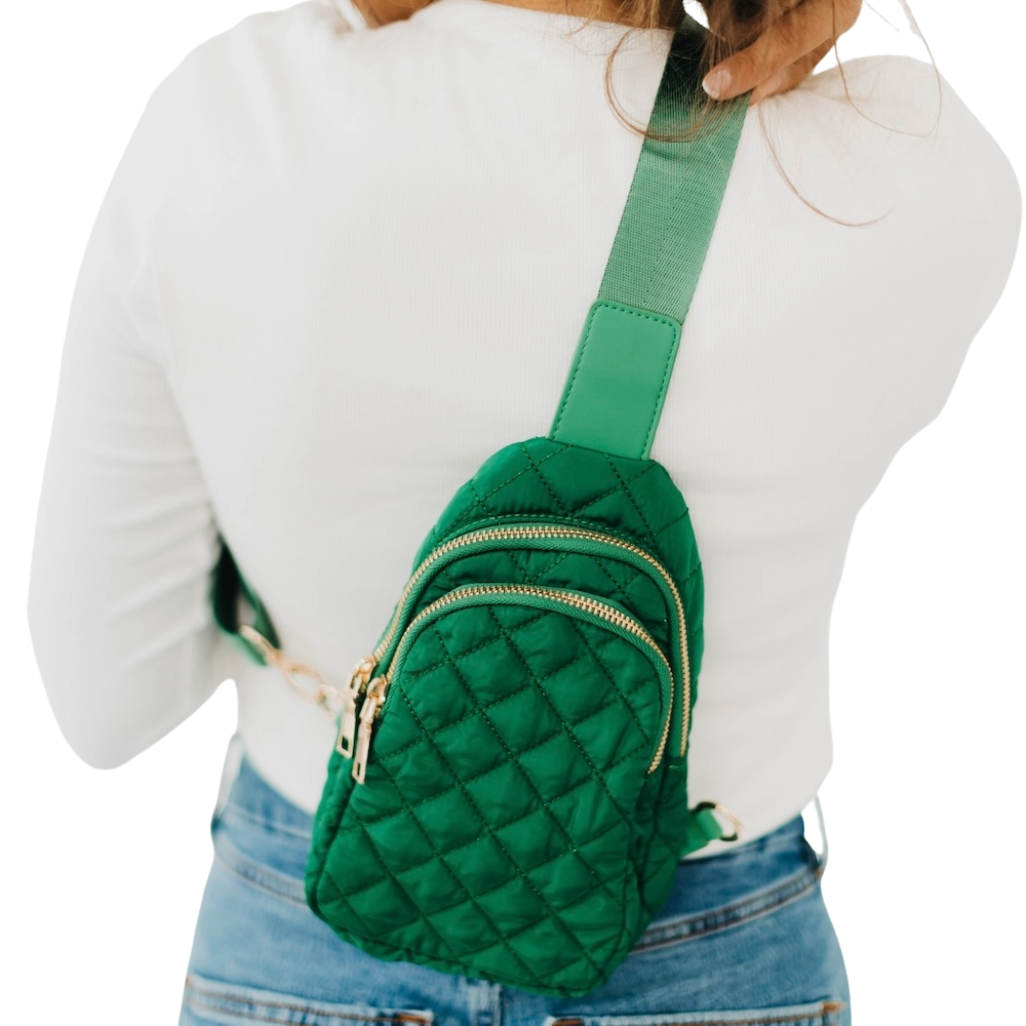 Green quilted crossbody bag worn by a person on a white background