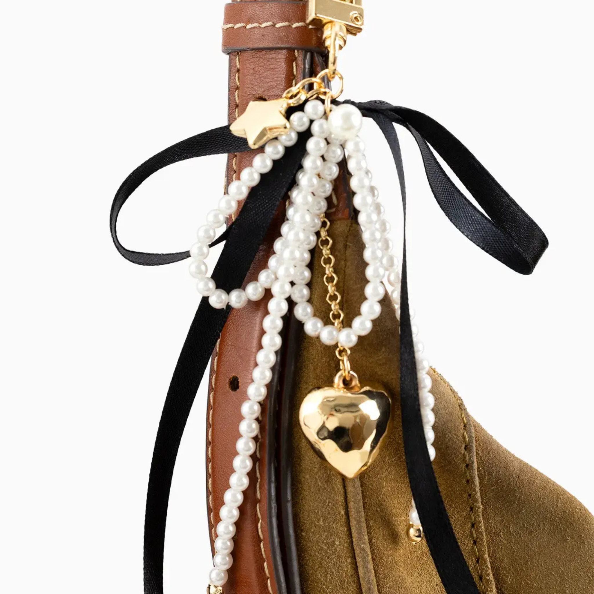 Pearl and gold heart charm on a brown leather bag with black ribbon