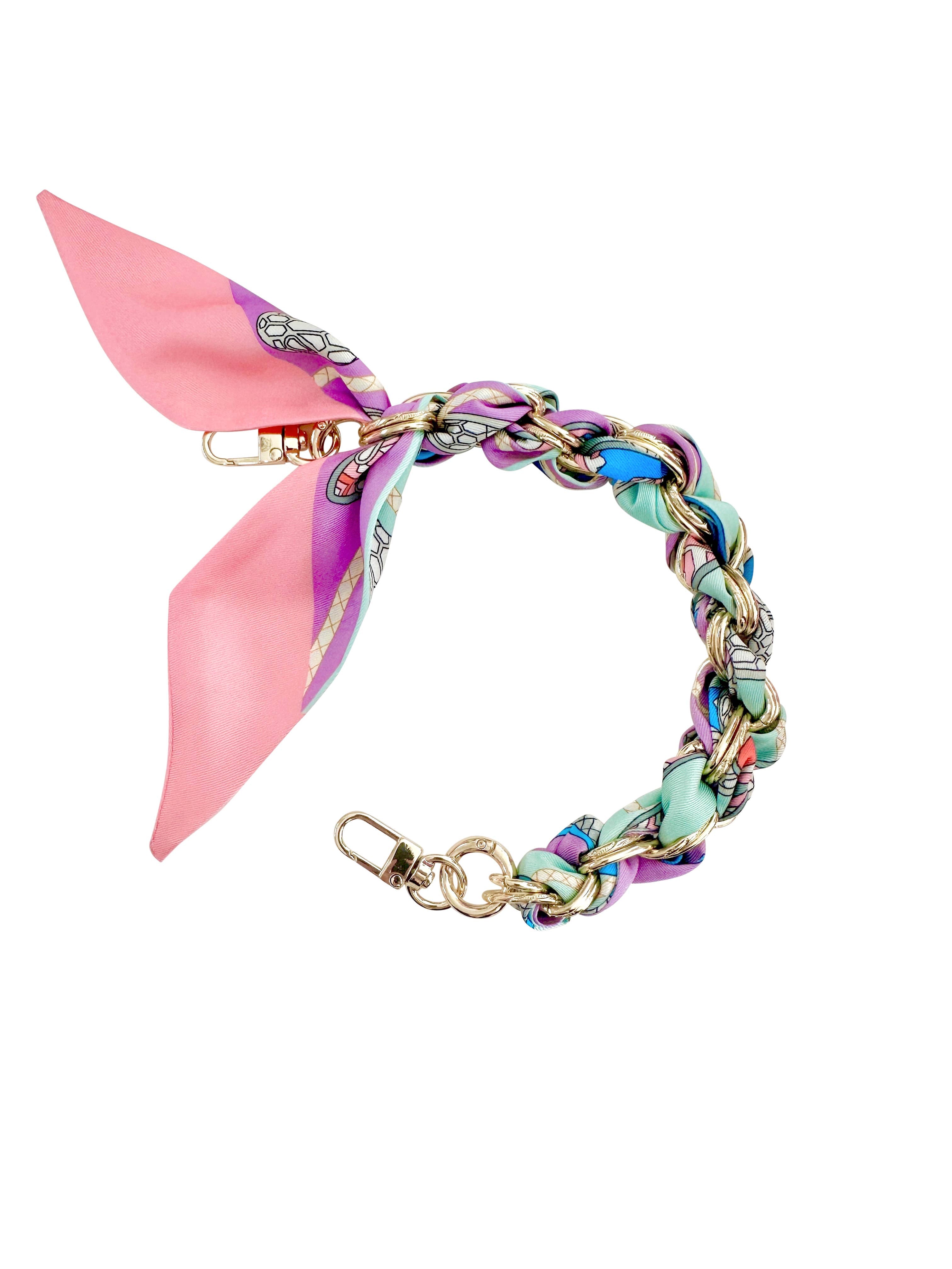 Gold phone chain with pastel print design, featuring a stylish and playful aesthetic by Gemelli.