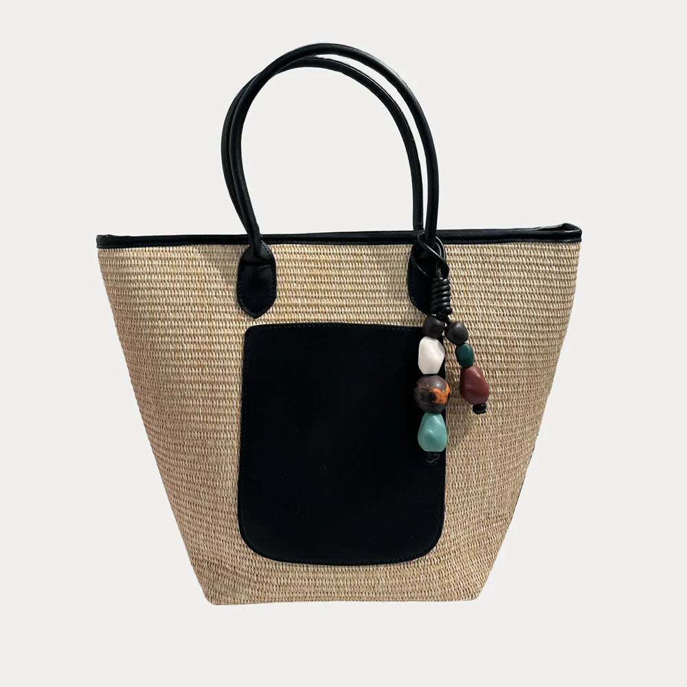 Large Camryn Raffia Tote bag by AHDORNED featuring woven raffia material and sturdy brown leather handles.